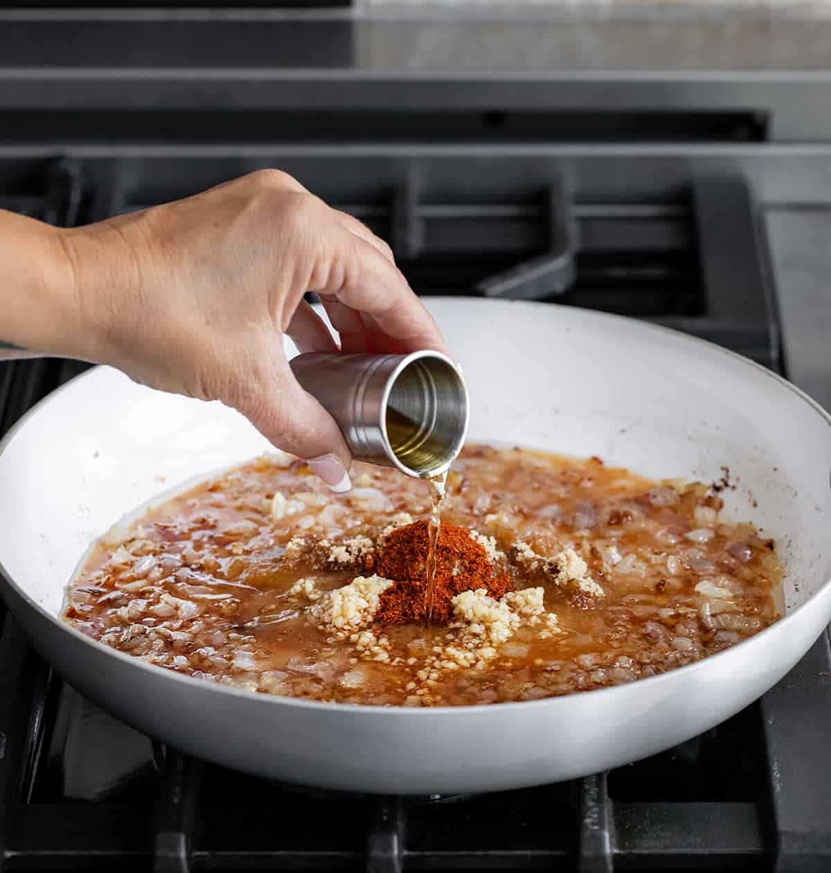 Adding Whiskey to Pan to Make Whiskey Bacon Jam.