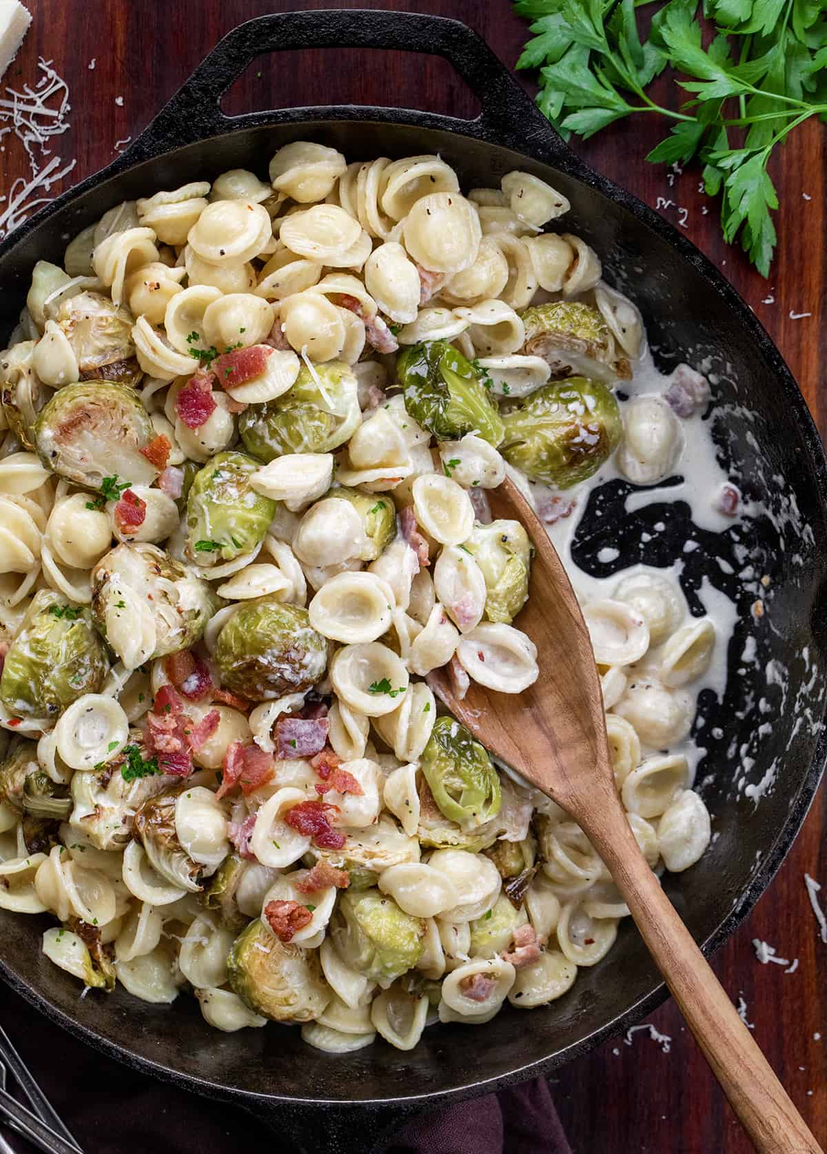 Pan of Roasted Brussels Sprouts Bacon Pasta on a woodne table. 