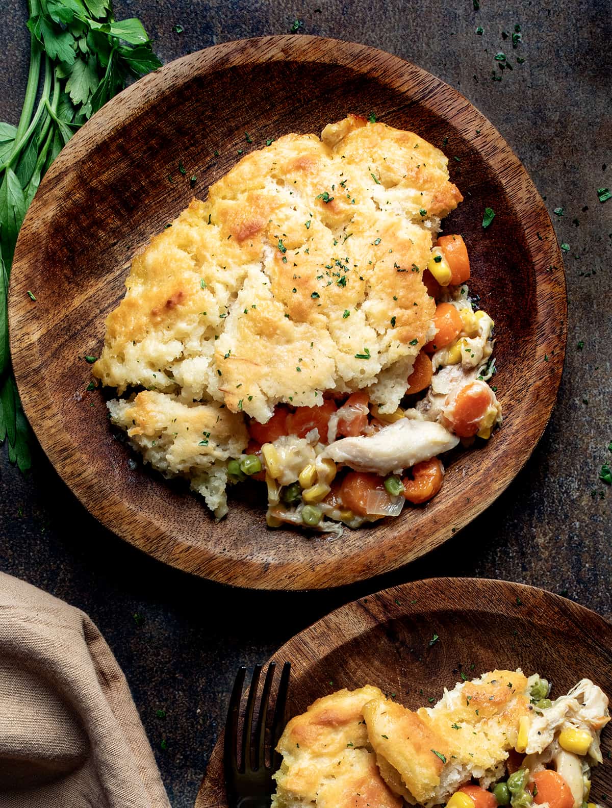 Plates of Butter Swim Biscuit Chicken Pot Pie and the Plates are Wooden.