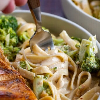 Fork Turning Noodles in a Cajun Chicken and Broccoli Alfredo Pasta Dish.