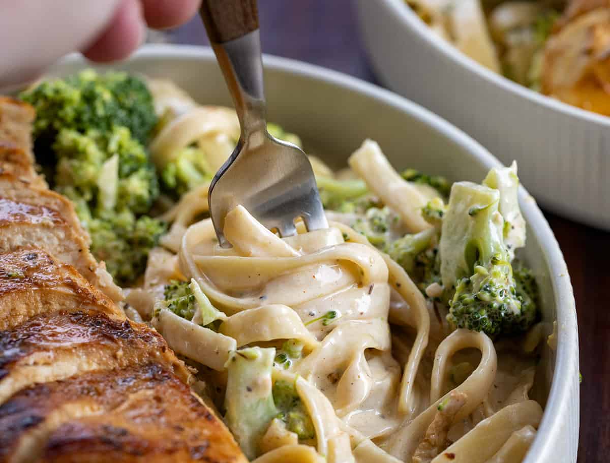 Fork Turning Noodles in a Cajun Chicken and Broccoli Alfredo Pasta Dish.