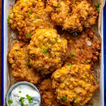 Pan of Corn Fritters from Overhead on a Dark Cutting Board.