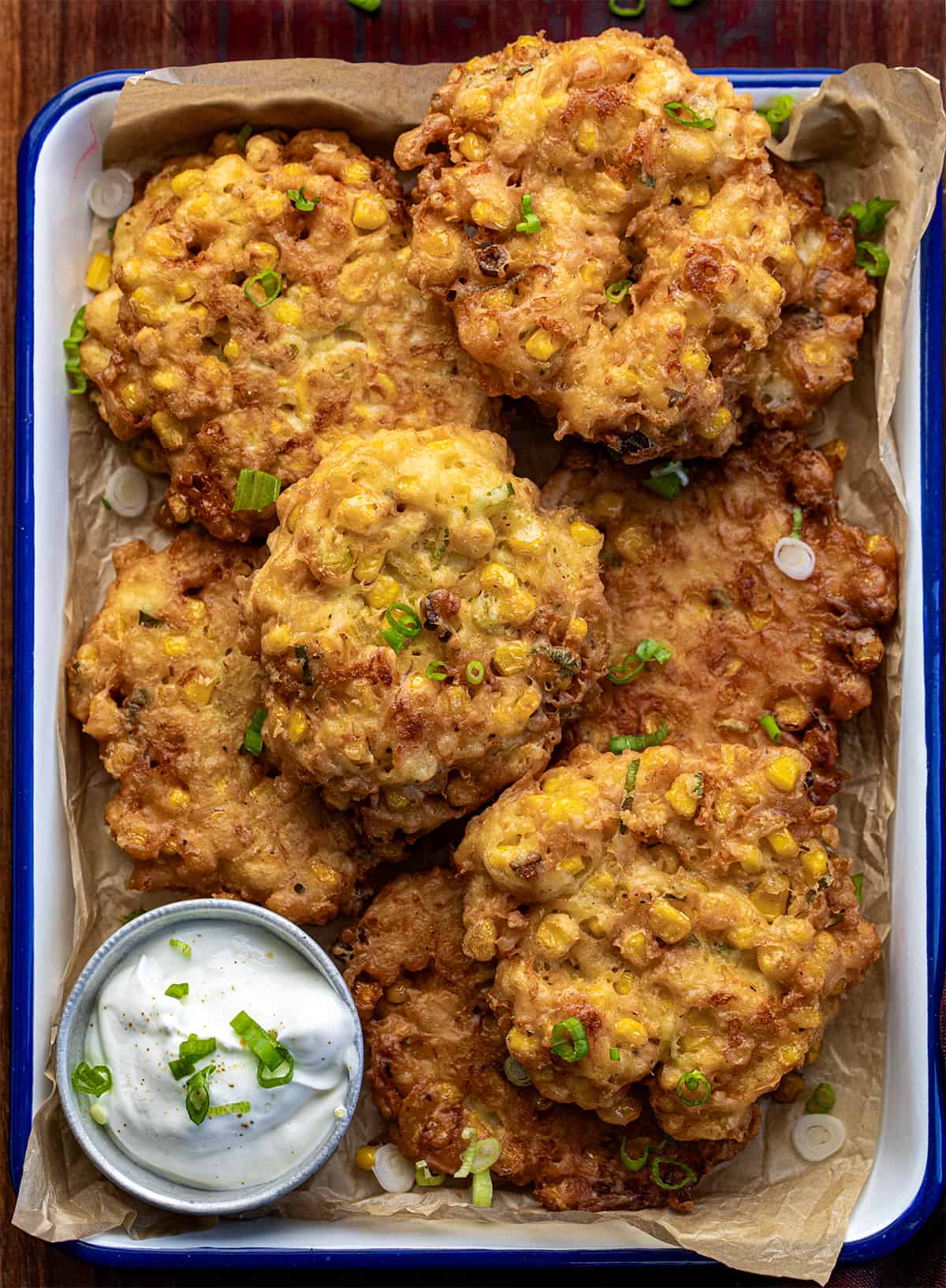Pan of Corn Fritters from Overhead on a Dark Cutting Board.