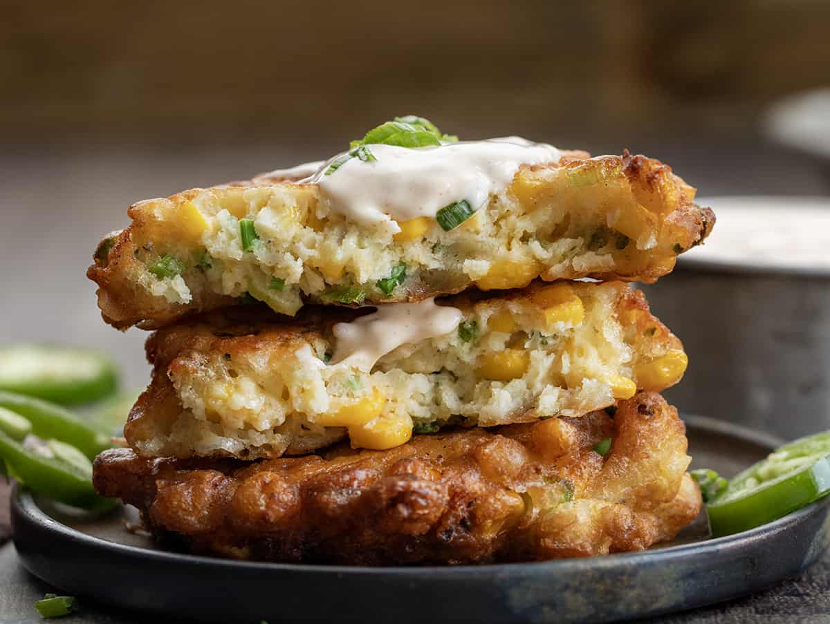 Jalapeno Corn Fritters on a Plate and Broken in Half Showing Inside.