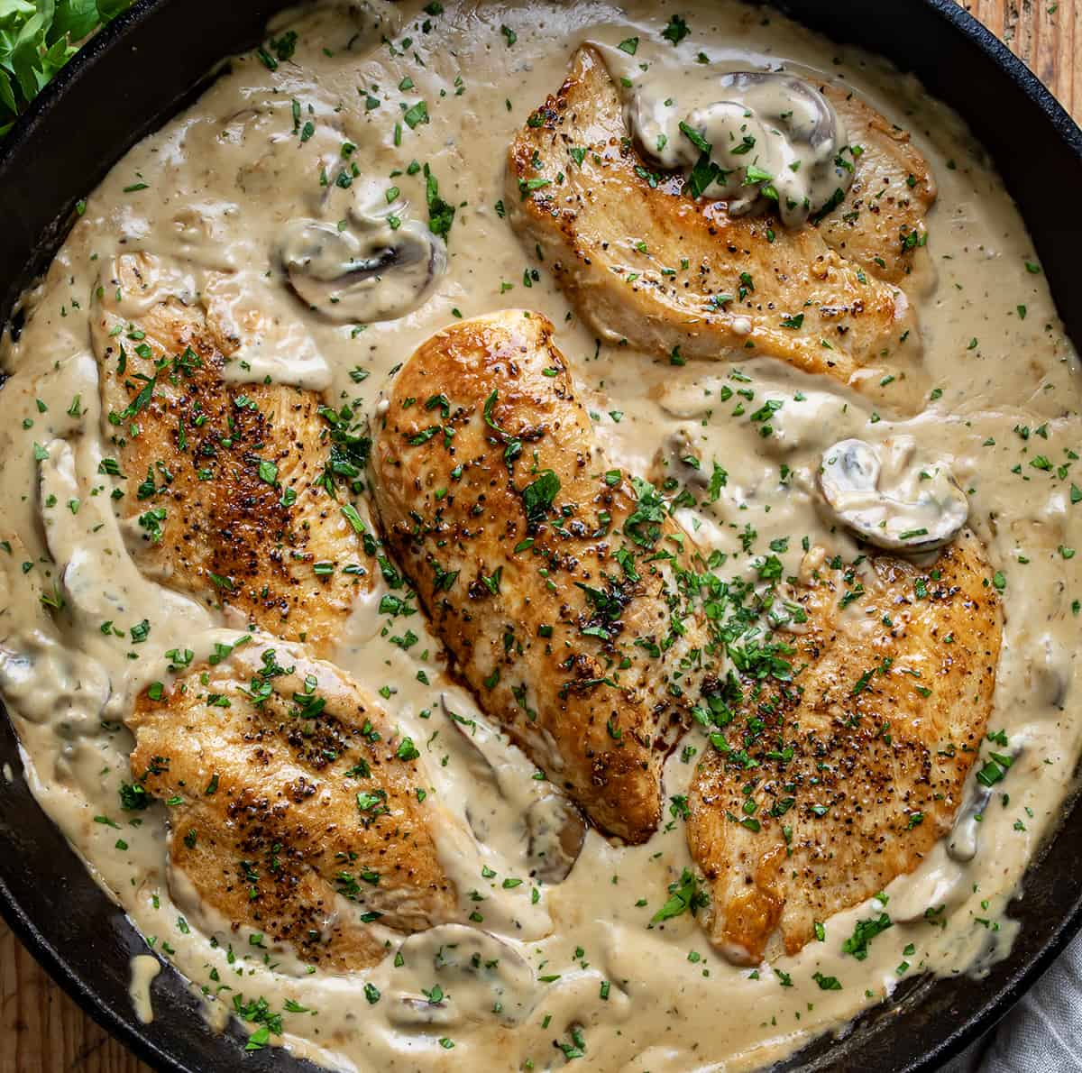 Skillet Filled with Chicken Breasts Nestled in a Mushroom Gravy Sauce from overhead.