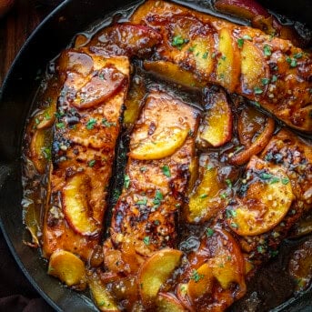 Bourbon Peach Roasted Salmon in a Skillet from Overhead on a Dark Cutting Board.