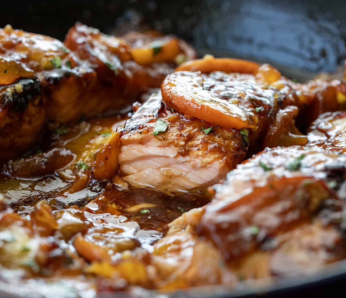 Piece of Bourbon Peach Roasted Salmon in a Pan with Some Removed so Inside is Seen.