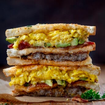 Stacked breakfast club sandwich on a wooden table.