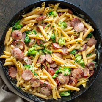 A Creamy Kielbasa Broccoli Skillet on a Dark Table from Overhead.