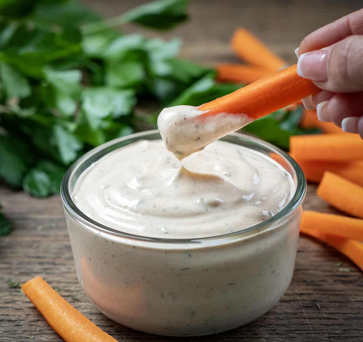 Dipping Carrot into a Bowl of Cowboy Ranch Dressing.