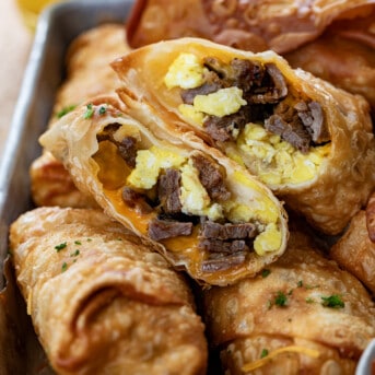 Close up of Cut in Half Steak Egg and Cheese Egg Rolls Showing Steak and Scrambled Eggs Inside.