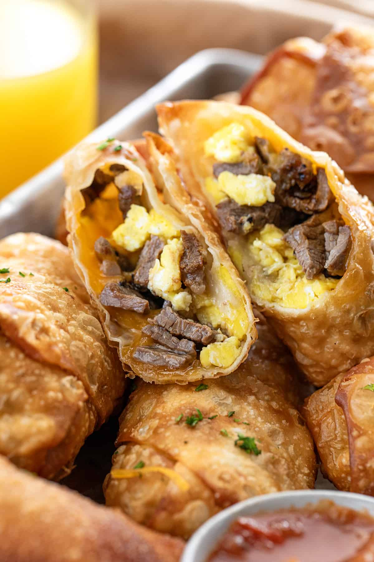 Close up of Cut in Half Steak Egg and Cheese Egg Rolls Showing Steak and Scrambled Eggs Inside.