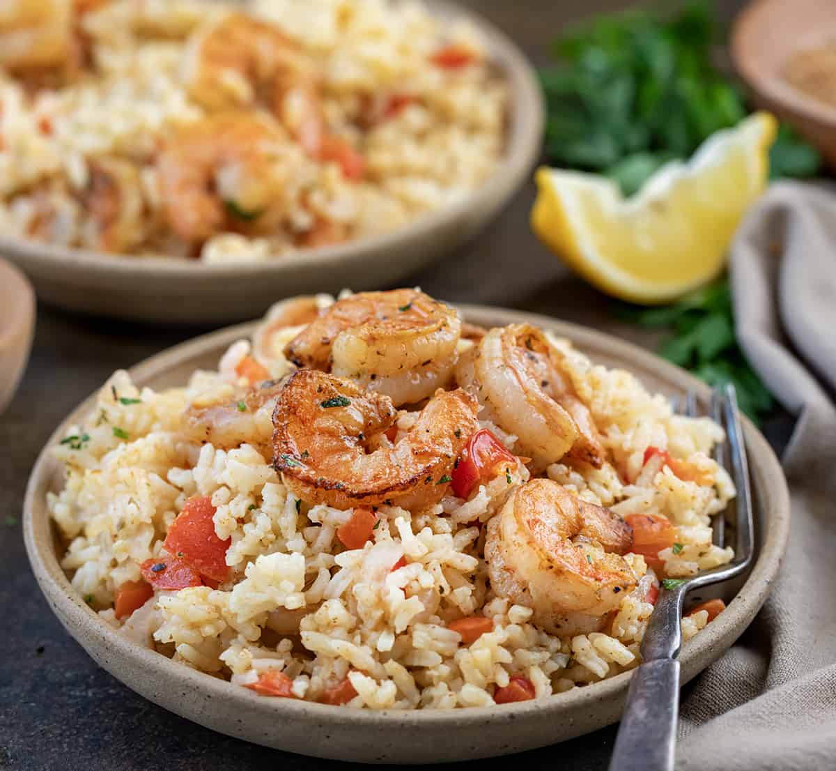 Plates of Cajun Shrimp and Rice with Forks, Lemon, and a Towel.