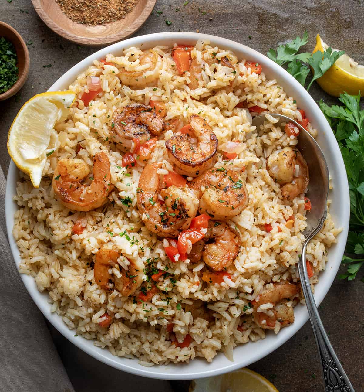 Bowl of Cajun Shrimp and Rice on a Table with a Spoon in the Bowl.