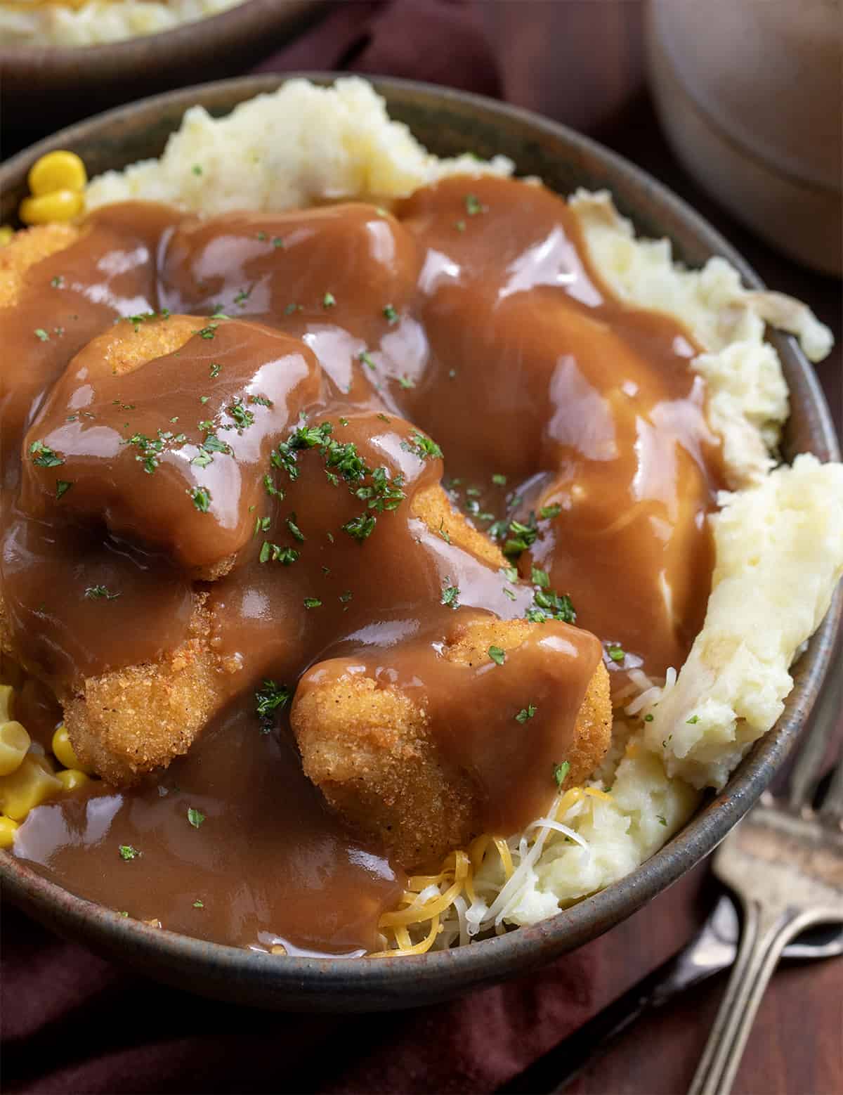 Close up of a Mashed Potato Bowl with Gravy Poured Over all the Chicken.