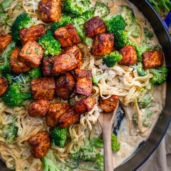 Skillet of Blackened Salmon and Broccoli Alfredo on a Table from Overhead.
