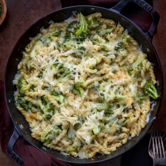 Broccoli Cheese Pasta in a Skillet on a Dark Table from Overhead.