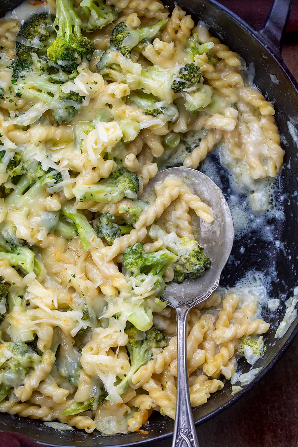 Spoon in a Pan of Broccoli Cheese Pasta with Some Removed.