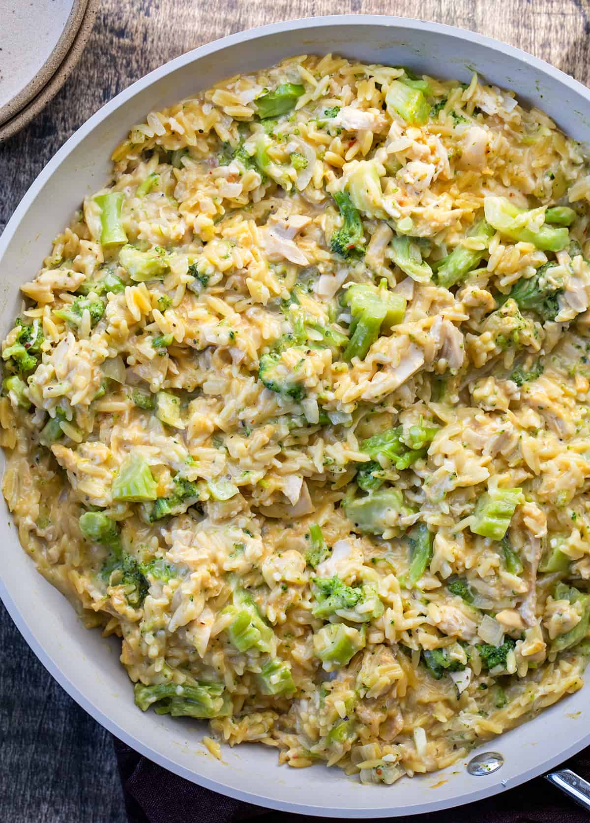 Closeup of Creamy Chicken and Broccoli Orzo in a skillet from overhead.