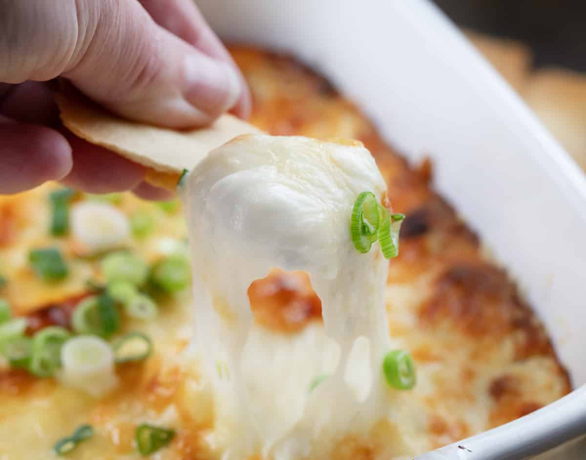 Scooping up cheesy Cheesy Roasted Garlic Dip.