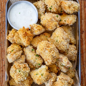 Pan of Baked Popcorn Chicken on a Wooden Table.