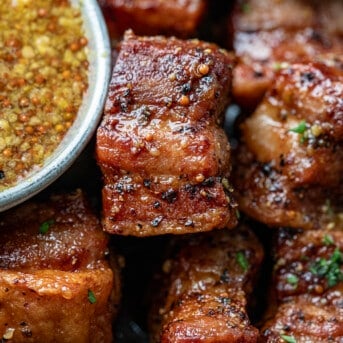 Close up of Maple Mustard Pork Belly Bites next to the sauce.