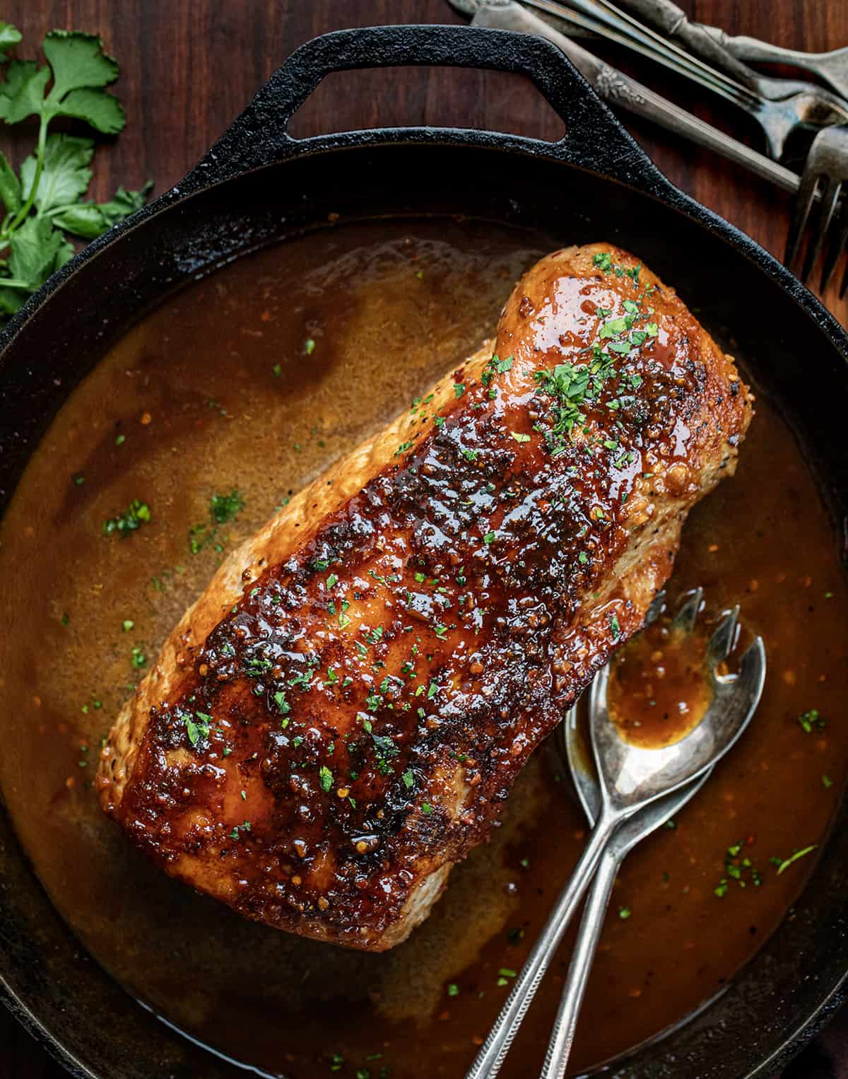 Honey Garlic Pork Loin in a Skillet on a Wooden Table from overhead.
