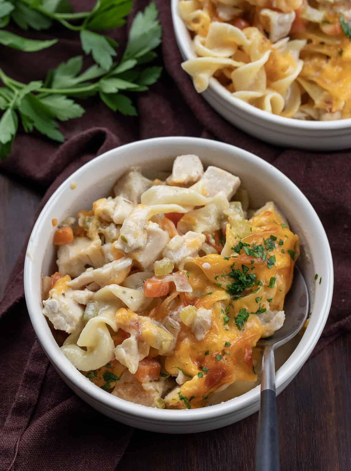 Individual bowls of Skillet Turkey Noodle Casserole with a spoon.