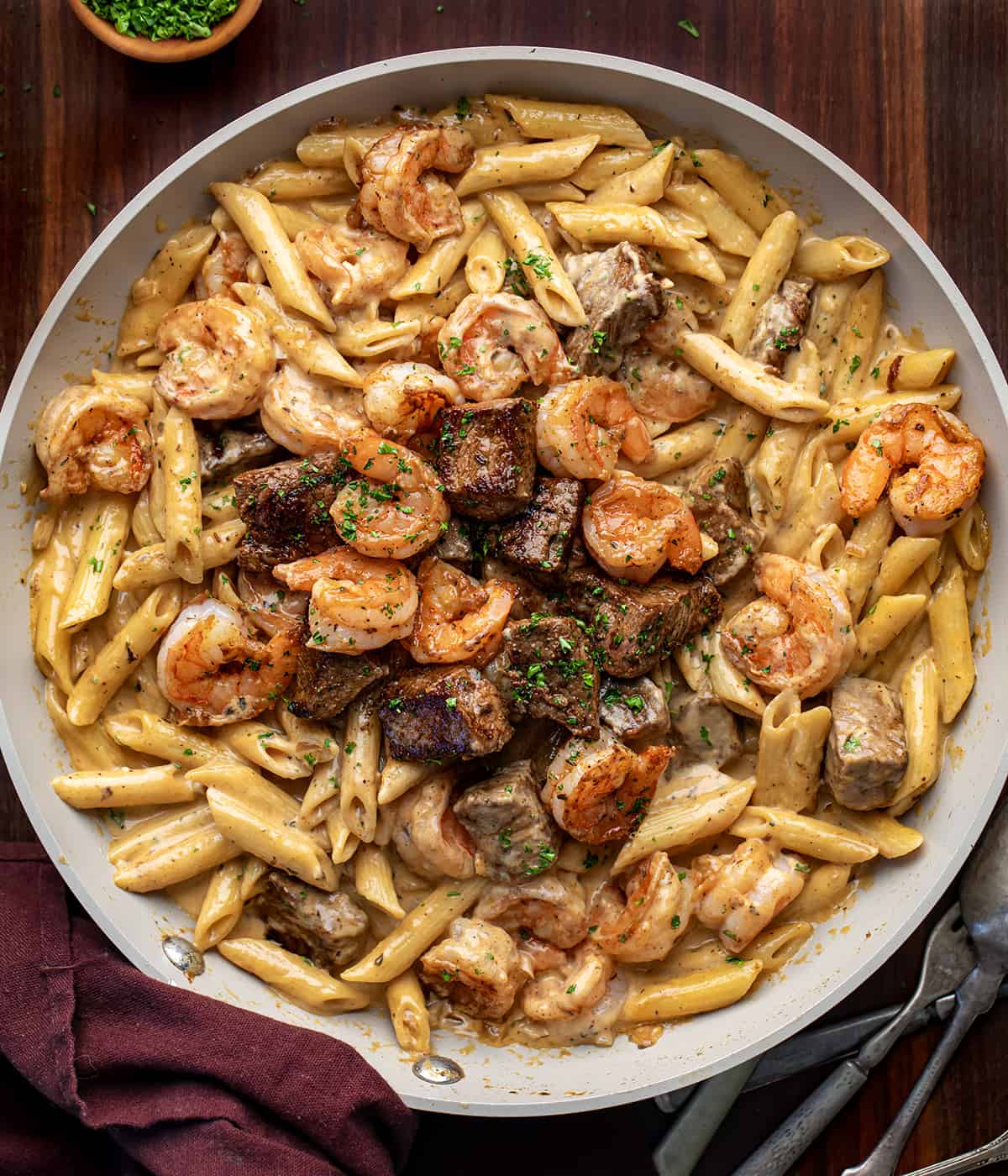 Blackened Steak and Shrimp Alfredo in a skillet from overhead.