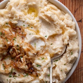 Bowl of French Onion Mashed Potatoes with a spoon.