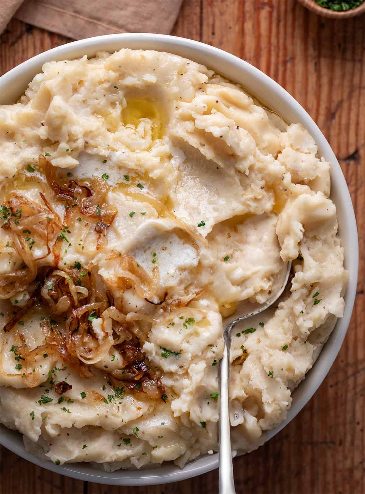 Bowl of French Onion Mashed Potatoes with a spoon.