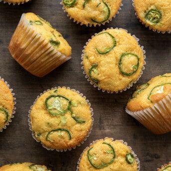 Jalapeno Cheddar Cornbread Muffins on a wooden table from overhead.
