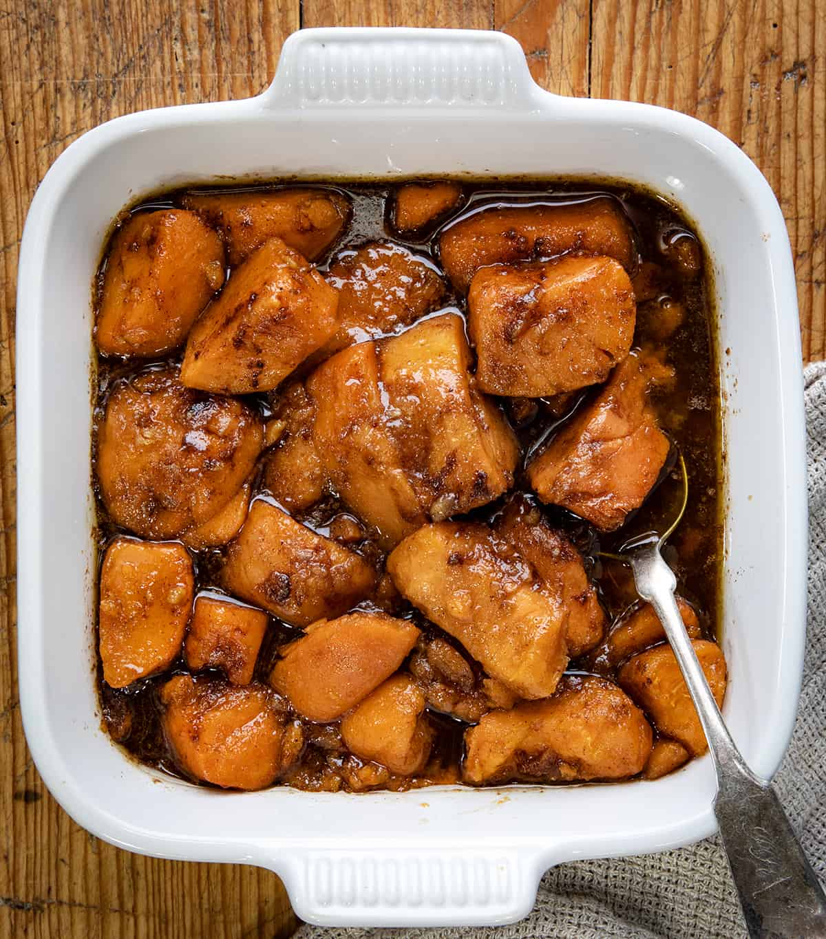 Pan of Easy Candied Yams on a table from overhead with a spoon.