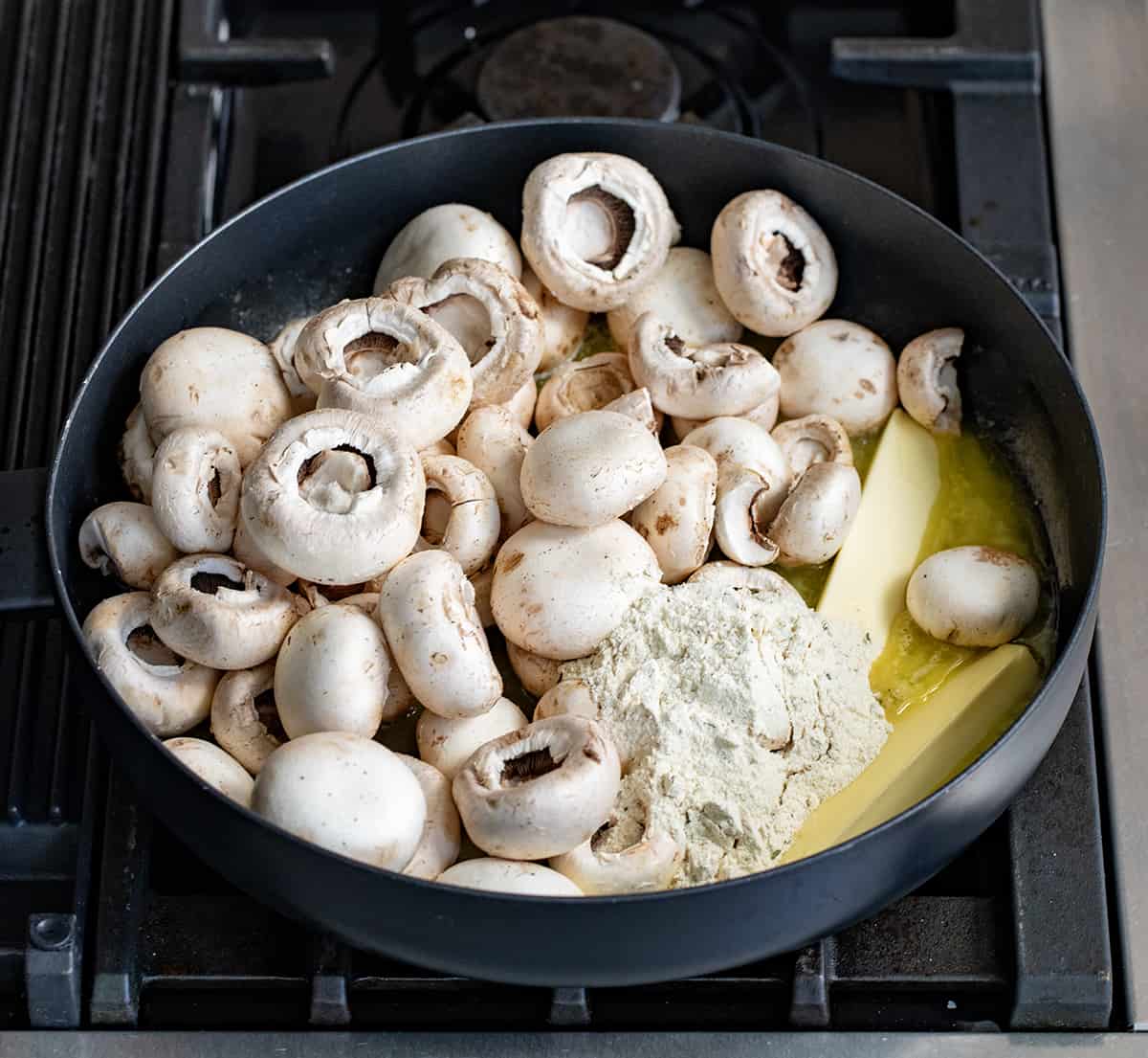 Mushrooms, ranch seasoning, and butter in a pan before heating to make Ranch Mushrooms.