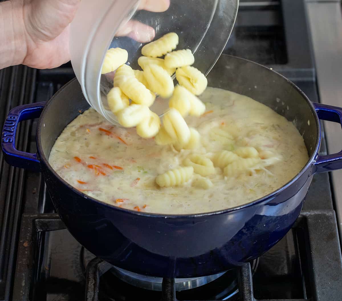 Adding gnocchi to a pot of Chicken Gnocchi Soup .