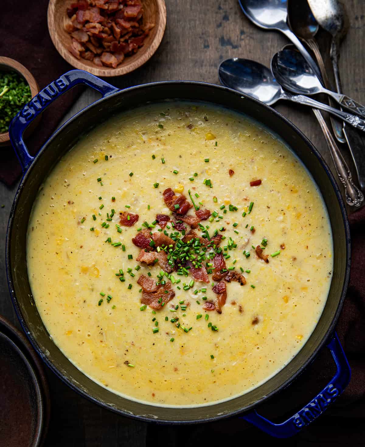 Overhead looking down on pot of Corn Chowder on a wooden table.