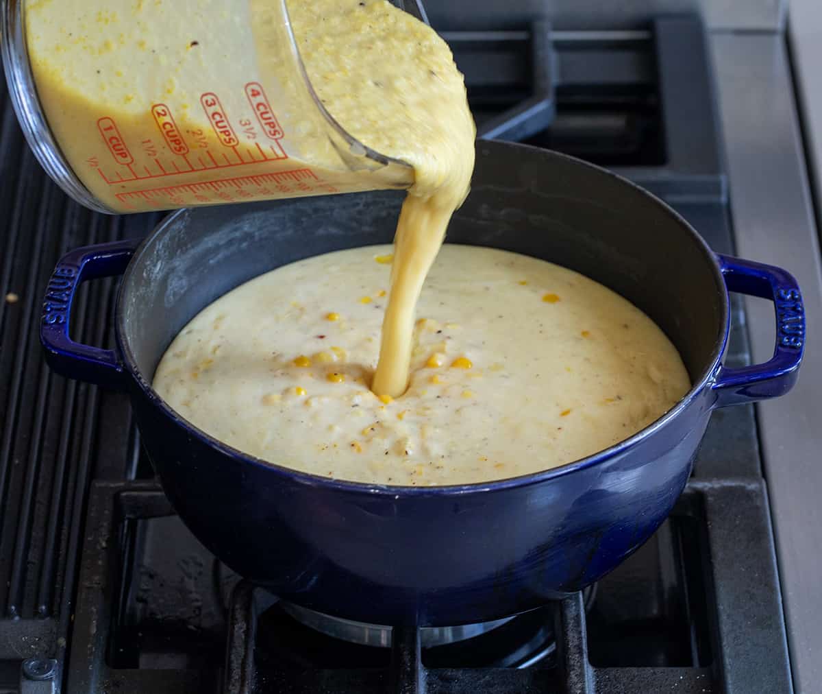 Pouring pureed corn into a pot of Corn Chowder.
