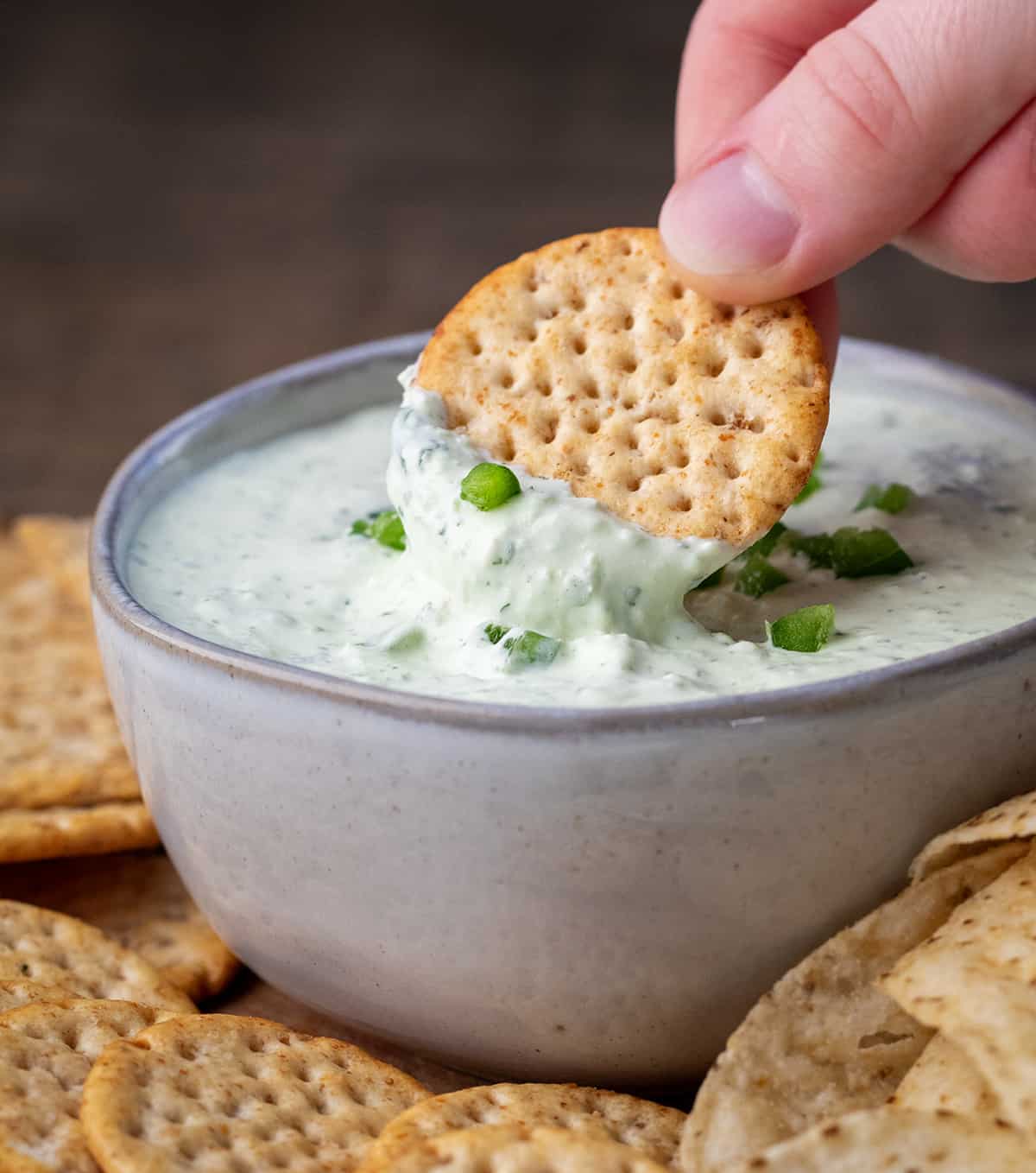 Dipping a chip into Creamy Jalapeno Dip.