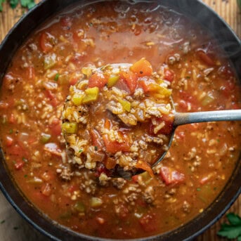 Using a ladle to scoop Stuffed Pepper Soup from the pot from overhead.