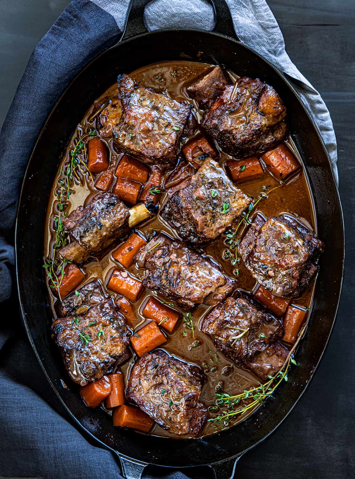 Pan of Wine Braised Short Ribs on a wooden table from overhead.
