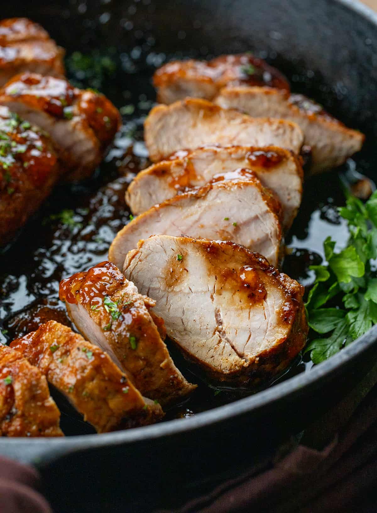 Slices of Pork Tenderloin With Apricot Glaze in a skillet.
