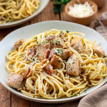 Plate of Chicken Carbonara on a wooden table with a napkin.