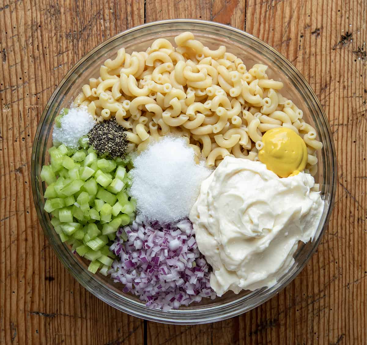 Raw ingredients for making Macaroni Salad in a bowl.
