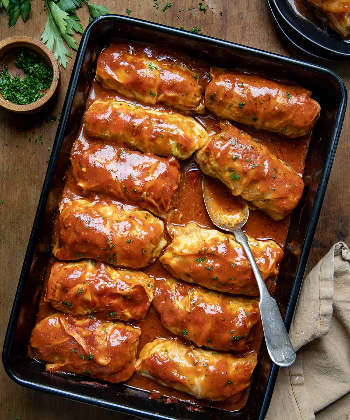 Pan of Cabbage Rolls with one roll removed and a spoon in the pan from overhead.