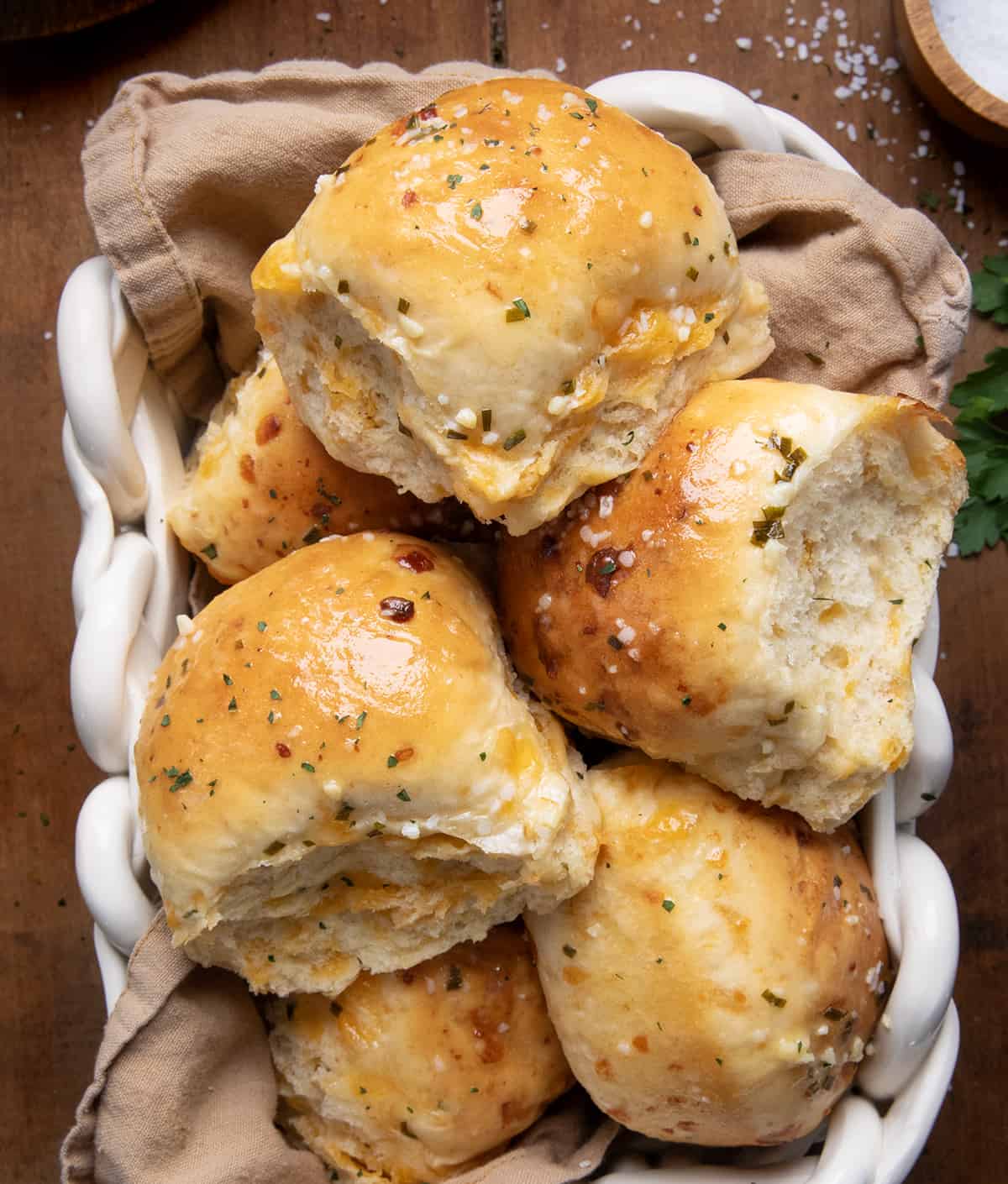 Cheesy Garlic Dinner Rolls in a basket on a wooden table from overhead.