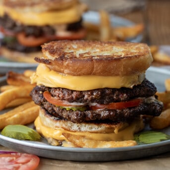 Grilled Cheese Burgers on a plate with fries.
