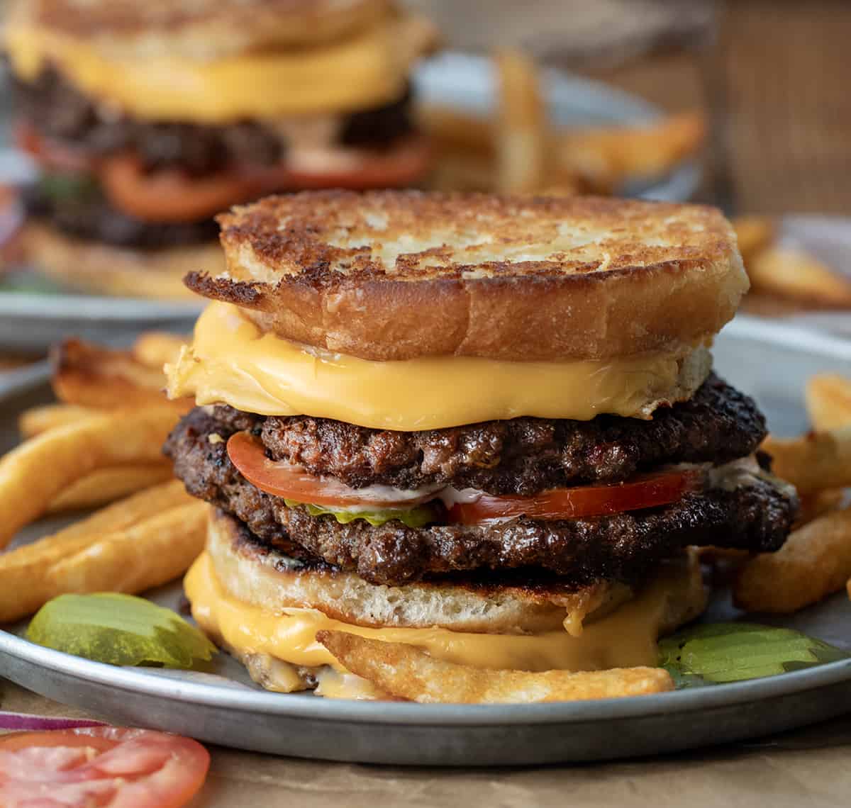 Grilled Cheese Burgers on a plate with fries. 