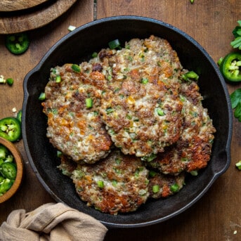 Jalapeno Cheese Sausage Patties in a skillet on a wooden table from overhead.