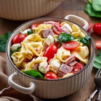 Bowl of Tortellini Pasta Salad on a wooden table.
