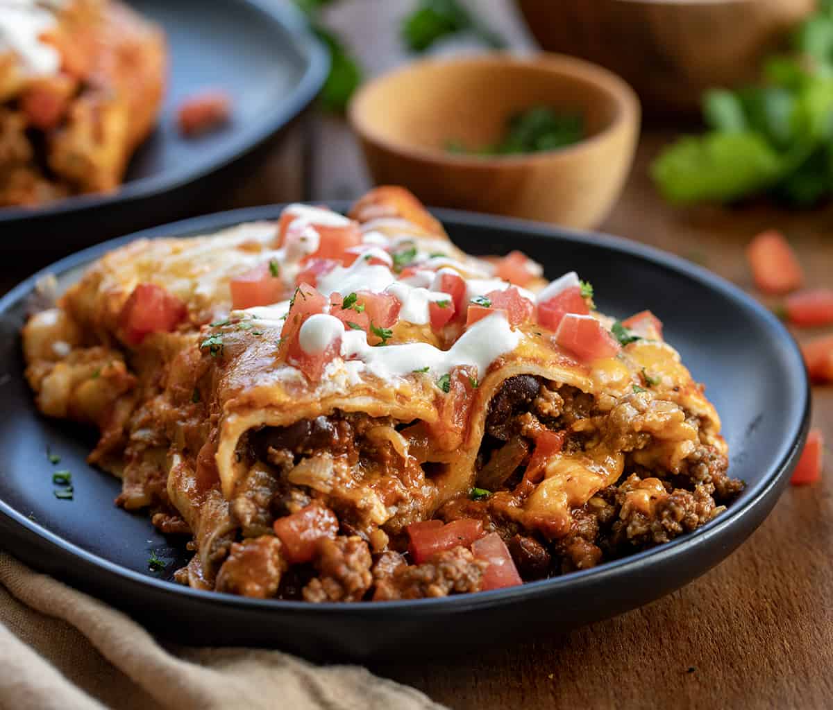 Two Beef Enchiladas on a plate showing the filling inside.